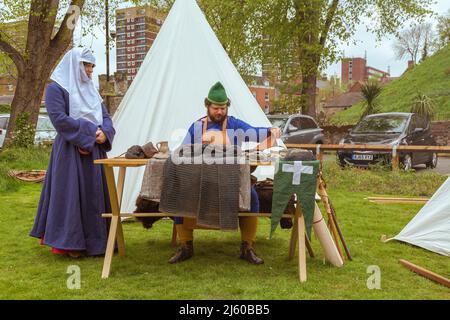Ein Waffengatter oder Heuberger zeigt Kettenpost, die er bei einer Nachstellung eines mittelalterlichen Lagers auf dem Gelände von Tamworth Castle, England, angefertigt hat. Stockfoto