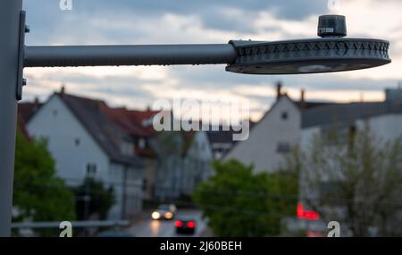 Heiningen, Deutschland. 26. April 2022. Auf der Straßenlaterne befindet sich die Bedienvorrichtung. An der örtlichen Durchgangsstraße soll die Beleuchtung an das nächtliche Verkehrsaufkommen angepasst werden, so dass Insekten geschützt werden sollen. Die Tiere werden vom Licht angezogen und sterben in den Lampen oder kreisen vor ihnen, bis sie erschöpft sind. Ein Kamerasystem wird auch verwendet, um die Insekten zu zählen. Quelle: Stefan Puchner/dpa/Alamy Live News Stockfoto