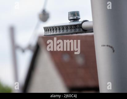 Heiningen, Deutschland. 26. April 2022. Auf einer Straßenlampe gibt es eine Steuerung, um die Helligkeit zu regulieren. An der örtlichen Durchgangsstraße soll die Beleuchtung an das nächtliche Verkehrsaufkommen angepasst werden, so dass Insekten geschützt werden sollen. Die Tiere werden vom Licht angezogen und sterben in den Leuchten oder kreisen vor ihnen, bis sie erschöpft sind. Ein Kamerasystem wird auch verwendet, um die Insekten zu zählen. Quelle: Stefan Puchner/dpa/Alamy Live News Stockfoto