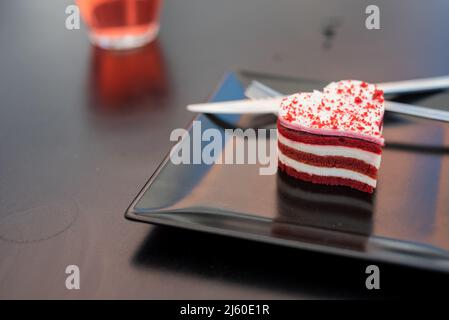 Roter Samtkuchen mit Tee und Kaffee auf der Terrasse eines städtischen Cafés Stockfoto