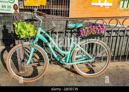 Vintage grünes Fahrrad mit Blumen gefüllten Körben in Sevilla Sevilla spanien Stockfoto