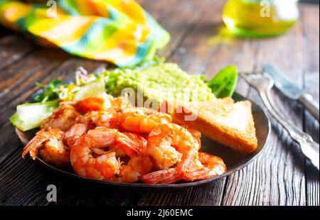 Gebratene Garnelen mit frischer Avocado und Toast Stockfoto