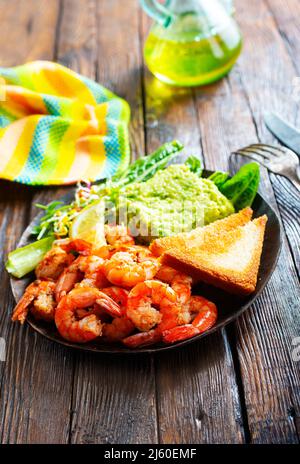 Gebratene Garnelen mit frischer Avocado und Toast Stockfoto