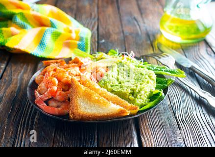 Gebratene Garnelen mit frischer Avocado und Toast Stockfoto