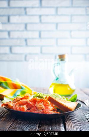 Gebratene Garnelen mit frischer Avocado und Toast Stockfoto