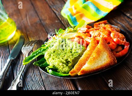 Gebratene Garnelen mit frischer Avocado und Toast Stockfoto