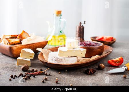 Camembert Käse mit Feigen, Himbeermarmelade. Rundbrie oder Camambert-Käse auf Schneidebrett Stockfoto