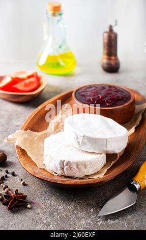 Camembert Käse mit Feigen, Himbeermarmelade. Rundbrie oder Camambert-Käse auf Schneidebrett Stockfoto