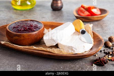 Camembert Käse mit Feigen, Himbeermarmelade. Rundbrie oder Camambert-Käse auf Schneidebrett Stockfoto