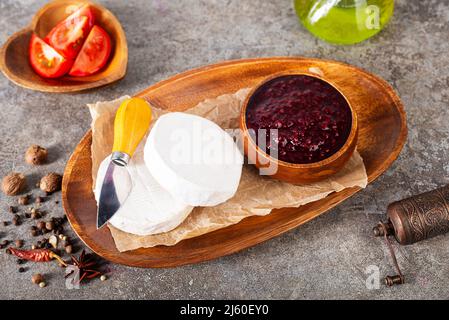 Camembert Käse mit Feigen, Himbeermarmelade. Rundbrie oder Camambert-Käse auf Schneidebrett Stockfoto