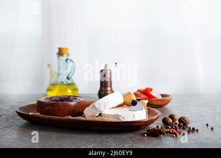 Camembert Käse mit Feigen, Himbeermarmelade. Rundbrie oder Camambert-Käse auf Schneidebrett Stockfoto