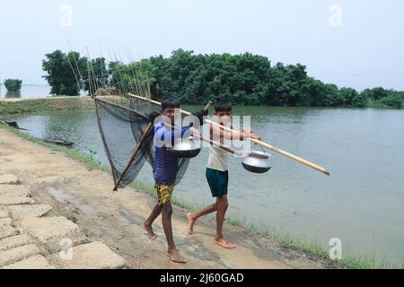 Sunamganj, Bangladesch. 19. April 2022. Junge Fischer mit ihren Fischernetzen am Tanguar Haor in Sunamganj. Tanguar Haor ist ein Feuchtgebiet im Bezirk Sunamganj im Großraum Sylhet in Bangladesch. Dieser Haor erstreckt sich über eine Fläche von etwa 100sq km und ist das zweitgrößte Süßwasser-Feuchtgebiet in Bangladesch. Für die Einheimischen ist der Haor auch als Nayakuri Kandar Chayakuri Beel bekannt. (Foto von MD Manik/SOPA Images/Sipa USA) Quelle: SIPA USA/Alamy Live News Stockfoto