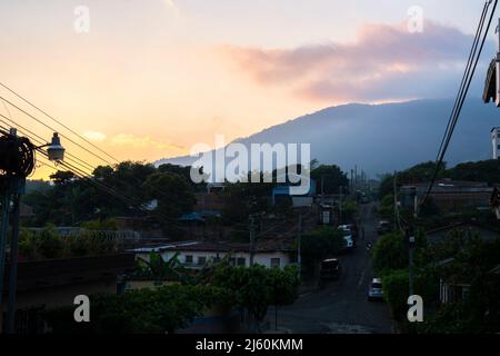 Ruta de las Flores, El Salvador - 29. Januar 2022: Blick auf eine leere Straße mit geparkten Autos im Wohngebiet von Juayua, El Salvador bei Sonnenuntergang Stockfoto