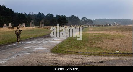 US-Soldaten, die dem Hauptquartier und dem Hauptquartier Battery, dem Bataillon 3., dem Artillerieregiment 29. (3-29. FA), dem Kampfteam der 3. Panzerbrigade und der Infanterie-Division 4. zugewiesen wurden, marschieren in die Reichweite, bevor sie ihre Waffen in Torun, Polen, am 20. April 2022 zerschießen. Der Verband 3-29. ist unter anderem dem V Corps, dem amerikanischen Vorbereitungs-Korps in Europa, zugeordnet, das mit NATO-Verbündeten und regionalen Sicherheitspartnern zusammenarbeitet, um kampfglaubwürdige Kräfte bereitzustellen und gemeinsame, bilaterale und multinationale Trainingseinheiten durchzuführen. (USA Armee-Nationalgarde Foto von Staff Sgt. Gabriel River Stockfoto