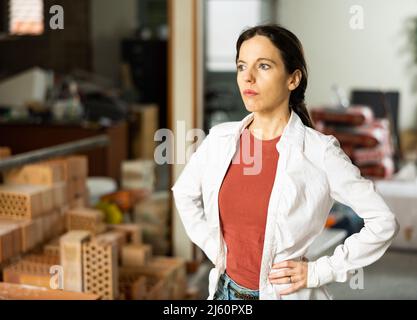 Selbstbewusste interessierte Frau, die während der Renovierung in ihrem Haus steht Stockfoto
