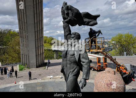 Kiew, Ukraine. 26. April 2022. Arbeiter demontieren das sowjetische Denkmal der ukrainisch-russischen Freundschaft, das 1982 als Symbol der Wiedervereinigung der Ukraine und Russlands während des russischen Einmarschs in die Ukraine errichtet wurde. Nach der Eskalation des Russland-Ukraine-Krieges kündigte Kiews Bürgermeister Witaliy Klitschko am 25. April 20222 an, dass die Skulpturenkomponente des Denkmals entfernt und der riesige Bogen über den Arbeitern umbenannt werden würde. Kredit: SOPA Images Limited/Alamy Live Nachrichten Stockfoto