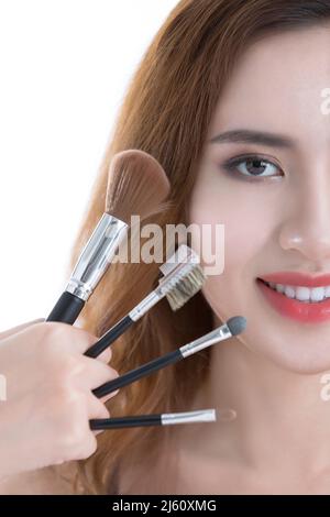 Kreative Fotografie. Make-up Künstler Hände und schöne junge chinesische Dame, auf weißem Hintergrund - Stock Foto Stockfoto