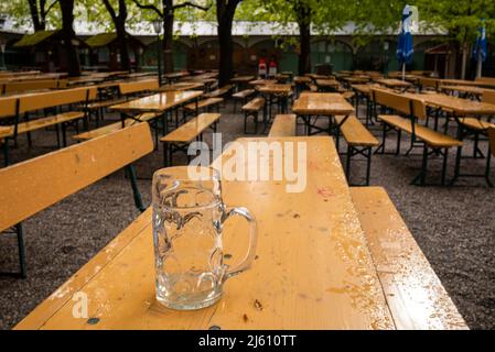 München, Deutschland. 26. April 2022. Ein leerer Bierkrug steht auf einer Bierbank in einem Biergarten im Stadtteil Haidhausen. Kredit: Peter Kneffel/dpa/Alamy Live Nachrichten Stockfoto