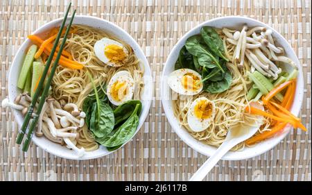 Draufsicht auf zwei Schüsseln frisch zubereiteter Pho-Suppe, fertig zum Essen. Stockfoto