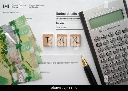 Calgary, Alberta - 24. April 2022: Steuerkonzept mit kanadischer Währung. Stockfoto