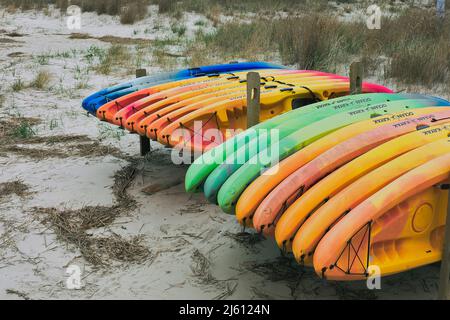 Mehrfarbige Plastikkajaks stehen bereit für die Vermietung am Cape Henloopen, Delaware Strand. Stockfoto