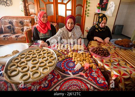 Gaza, Palästina. 26. April 2022. Eine palästinensische Familie stellt in ihrem Haus im zentralen Gazastreifen traditionelle Süßigkeiten her. Muslime auf der ganzen Welt bereiten sich darauf vor, den seligen Eid Al-Fitr zu feiern, der mit dem Ende des heiligen Monats Ramadan zusammenfällt. Kredit: SOPA Images Limited/Alamy Live Nachrichten Stockfoto