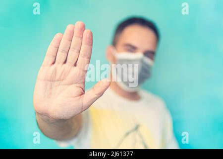 Stoppen Sie die Infektion. Gesunder Mann zeigt Geste stoppen. Mann tragen Schutzmaske gegen Infektionskrankheiten und Grippe. Gesundheitskonzept. Eintritt mit Stockfoto