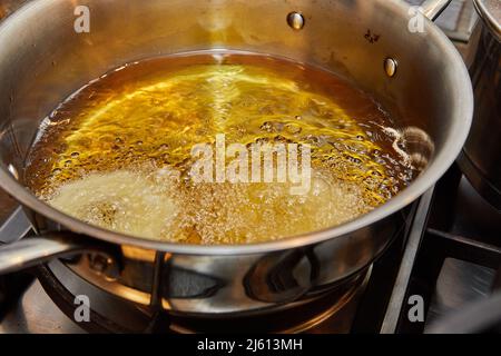 Kochen von Apfelpfannkuchen. Apfeldonut in kochendem Öl Stockfoto