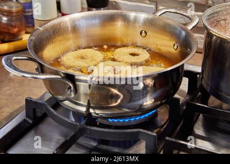 Kochen von Apfelpfannkuchen. Apfeldonut in kochendem Öl Stockfoto