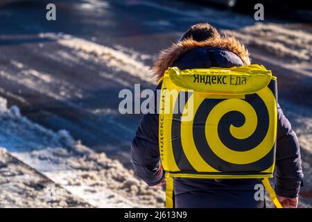 Minsk, Weißrussland - 19. Februar 2022: Ein Yandex Food-Kurier wird mit einer Bestellung an einen Kunden gesendet Stockfoto