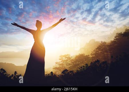 Frau erfolgreich Wandern Silhouette in den Bergen bei Sonnenuntergang Stockfoto