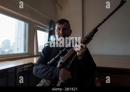 KIEW, UKRAINE 02. März. Ein Scharfschütze des Kiew-Verteidigungs-Bataillons posiert mit seinem Gewehr in einem Obergeschoß eines Bürogebäudes, während die russische Invasion der Ukraine am 02. März 2022 in Kiew, Ukraine, fortgesetzt wird. Russland begann eine militärische Invasion der Ukraine, nachdem das russische parlament Verträge mit zwei abtrünnigen Regionen in der Ostukraine gebilligt hatte. Es ist der größte militärische Konflikt in Europa seit dem Zweiten Weltkrieg Stockfoto