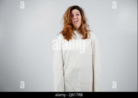 Nahaufnahme Porträt einer verrückten Frau in Zwangsjacke auf weißem Hintergrund. Stockfoto