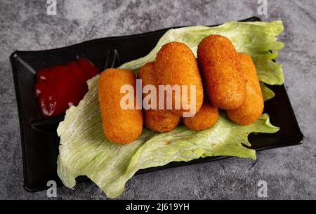 Traditionelle spanische hausgemachte Kroketten oder Kroketten auf einem Teller auf einem Salatblatt Stockfoto