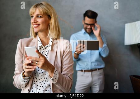Schöne erfolgreiche Geschäftsfrau E-Mails am Telefon in modernen Büro ich zu überprüfen Stockfoto