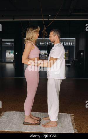 Ein Mann und eine Frau machen Yoga auf Brettern mit Nägeln im Fitnessstudio. Stockfoto