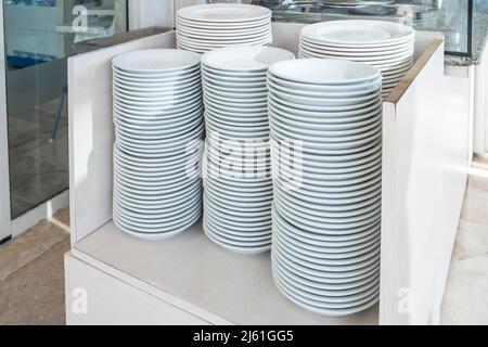 Weiße Gerichte auf dem Tisch in einem Buffetrestaurant. Stockfoto