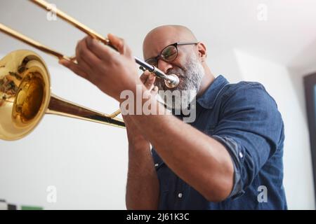 Porträt des Mannes spielt Posaune Stockfoto