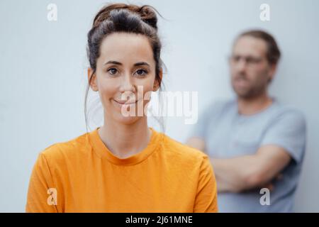 Lächelnde Frau, die vor dem Mann steht Stockfoto