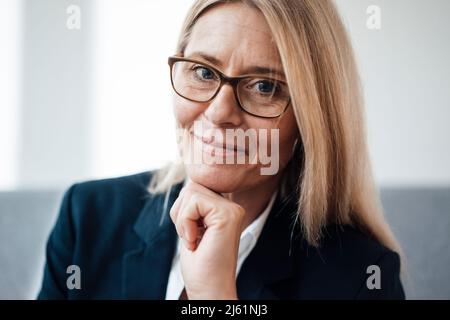 Geschäftsfrau mit Hand am Kinn im Büro Stockfoto