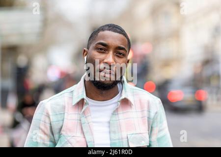 Mann mit kabellosen in-Ear-Kopfhörern im Freien Stockfoto