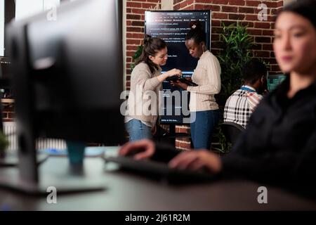 Softwareingenieure versuchen, Speicherplatzprobleme mithilfe moderner künstlicher Intelligenz zu lösen. Multirassisches Entwicklerteam, das über eine steigende Anzahl von Sicherheitsverstößen im System spricht. Stockfoto
