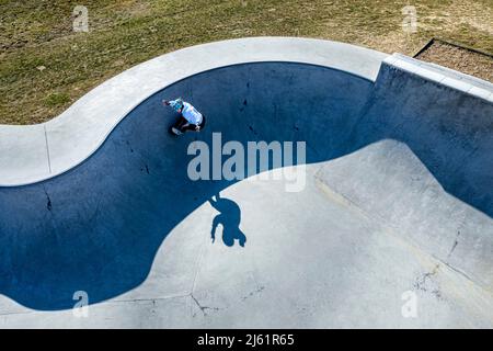 Junge Skateboarderin übt an sonnigen Tagen auf der Pump Track Stockfoto