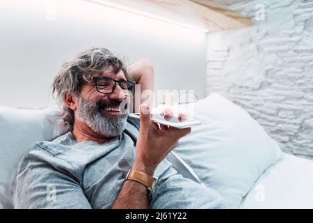 Glücklicher Mann telefonieren mit Handy zu Hause Stockfoto