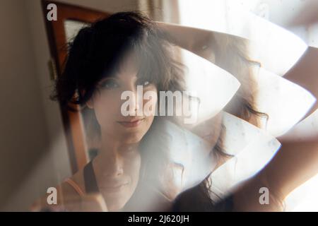 Schöne junge Frau mit der Hand hinter den Haaren Stockfoto