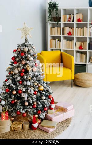 Geschmückter Weihnachtsbaum inmitten von Geschenken im Wohnzimmer zu Hause Stockfoto