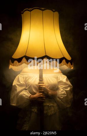 Frau, die eine beleuchtete Rauchlampe vor dem Gesicht hält Stockfoto