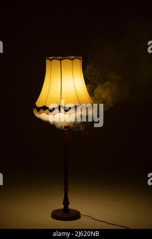 Beleuchtete Rauchlampe im dunklen Raum Stockfoto