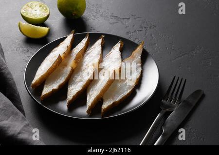 Köstliche geräucherte Heilbutt-Scheiben mit Limettenhintergrund serviert. Blick von oben. Speicherplatz kopieren. Stockfoto