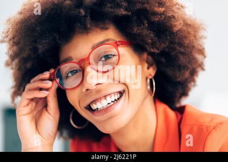 Fröhliche Geschäftsfrau mit Afro-Frisur und Brillen Stockfoto